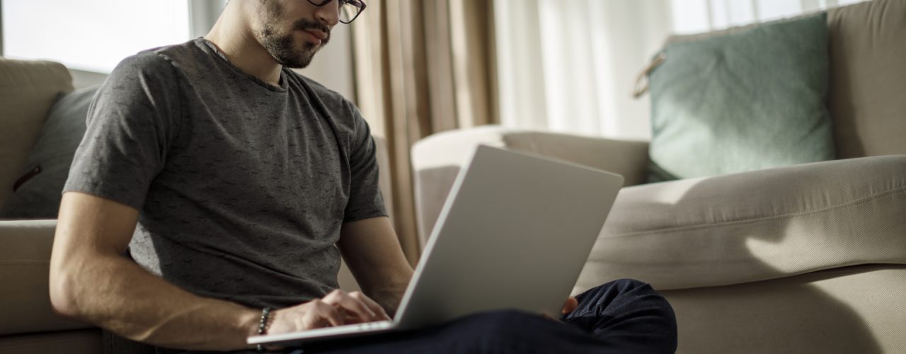 Teenage boy working on laptop at home